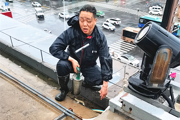 工作人員顧不上擦去臉上的泥水 一心疏通樓頂管道_副本.jpg